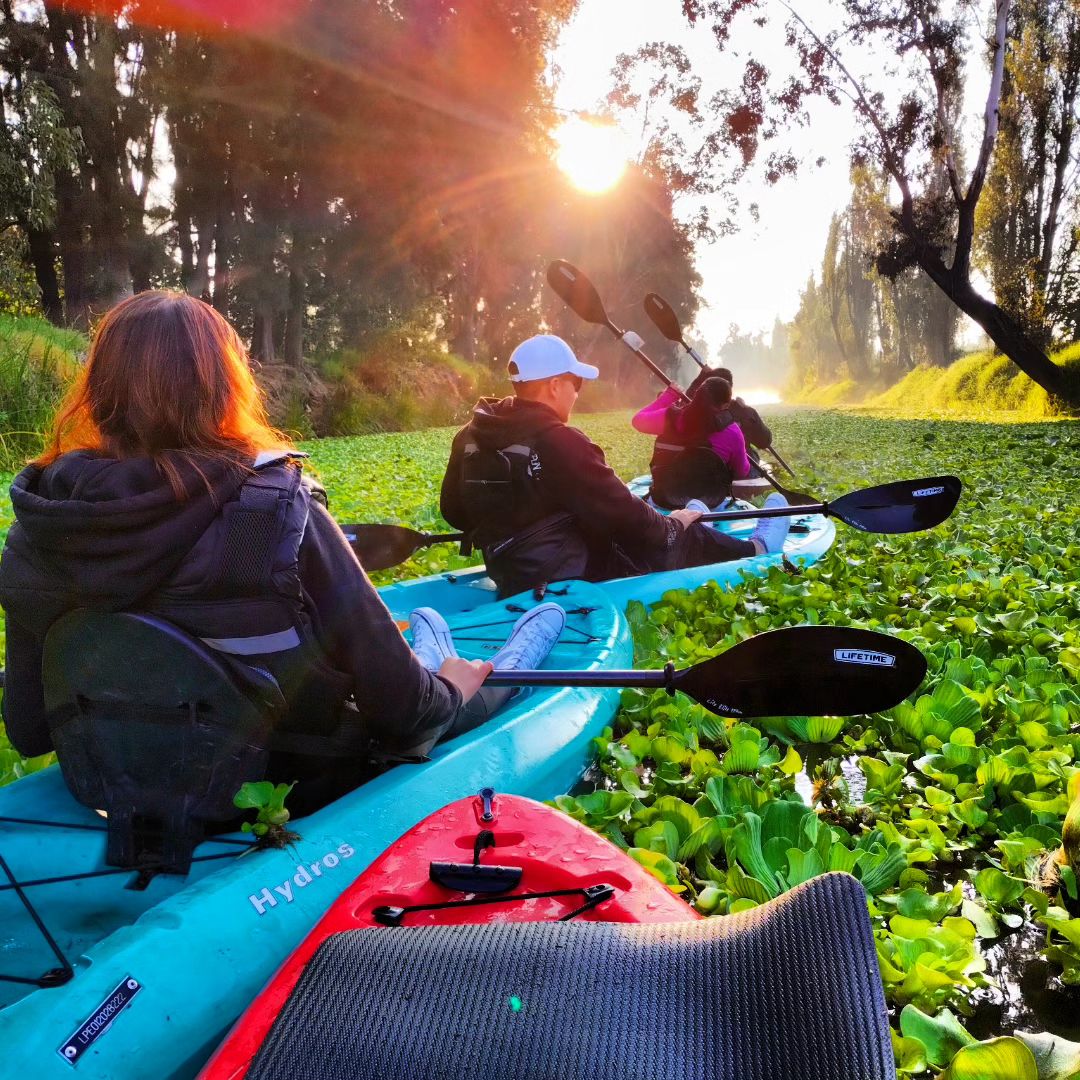 Guía de La Kanoa preparando los kayaks al atardecer